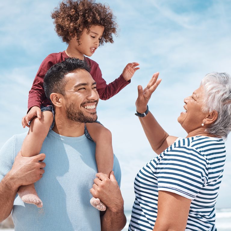Three generations of a family laughing together outdoors